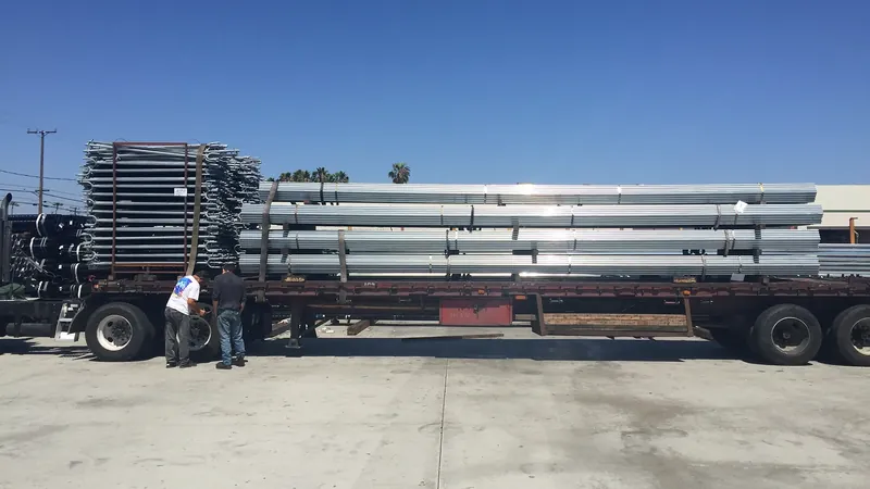 Flatbed truck loaded with bundled hoop-house tubing and fabricated components