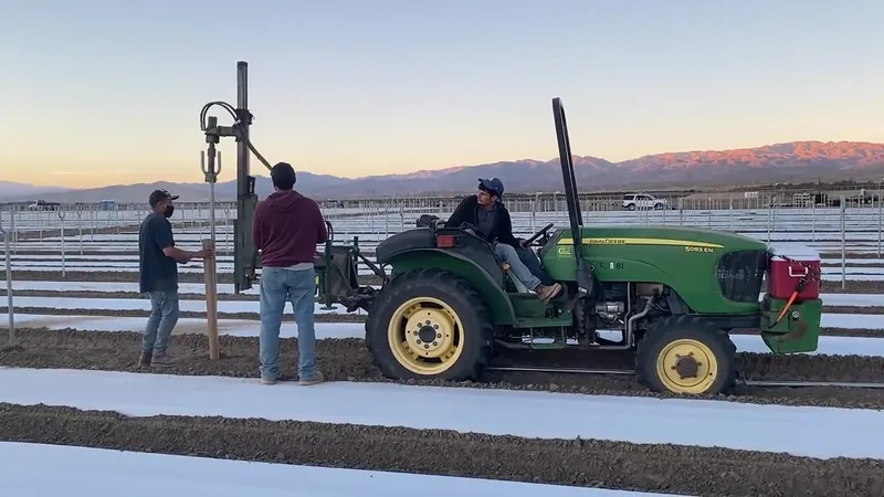 Farm equipment and local crew installing hoop-house platforms